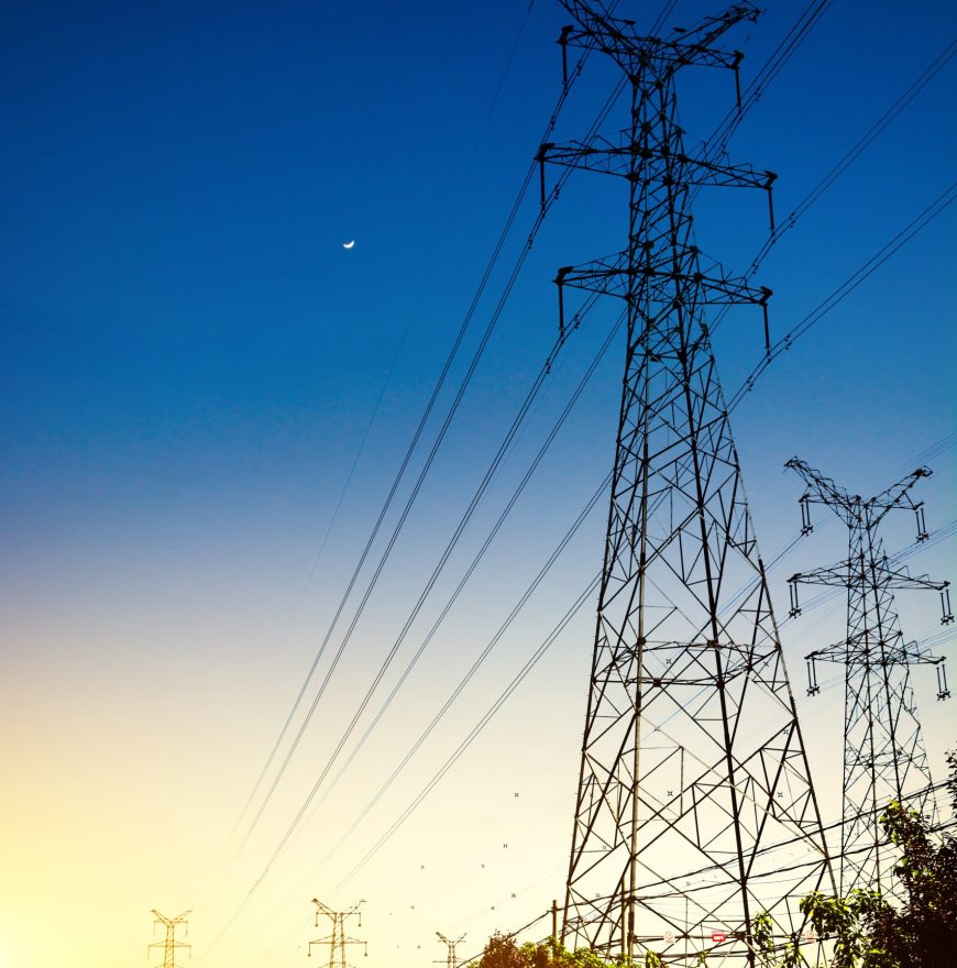 Sun setting behind the silhouette of electricity pylons Sun setting behind the silhouette of electricity pylons